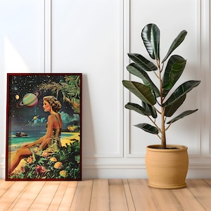 May include: A framed print of a woman sitting on a beach with a planet in the background. The woman is wearing a yellow dress and has her hair pulled back. The print is in a dark wood frame and is hanging on a white wall.
