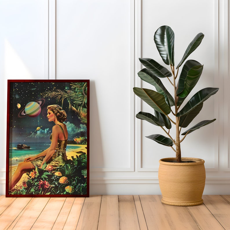 May include: A framed print of a woman sitting on a beach with a planet in the background. The woman is wearing a yellow dress and has her hair pulled back. The print is in a dark wood frame and is hanging on a white wall.