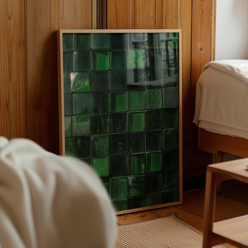 May include: A framed artwork featuring a grid of dark green, textured squares. The artwork is encased in a light-colored wooden frame and leans against a wooden wall. The overall aesthetic is modern and abstract.