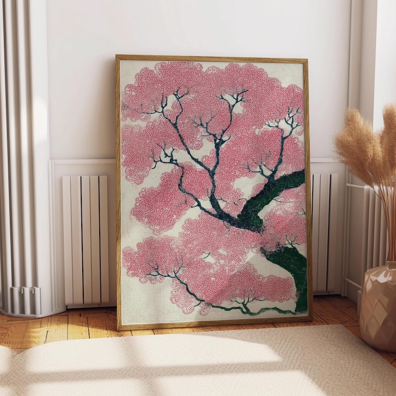 May include: A framed art print featuring a stylized pink cherry blossom tree. The artwork has a vintage aesthetic with a light background and a wooden frame. The tree's branches are dark, and the blossoms are a vibrant pink.
