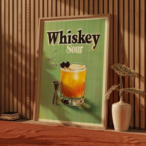 May include: A vintage-style poster with a green background featuring the text "Whiskey Sour" in black lettering. A glass of whiskey sour with maraschino cherries is depicted in the centre of the poster.