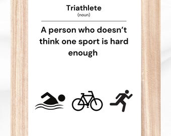 May include: A framed print with a definition of a triathlete. The definition reads: "A person who doesn't think one sport is hard enough." The print includes icons for swimming, cycling, and running.