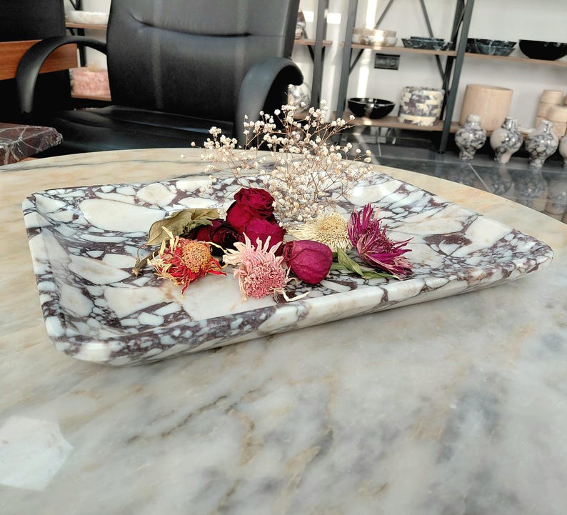 May include: A rectangular marble tray with a white and purple veined pattern. The tray holds dried flowers in shades of red, pink, and yellow. The tray is a decorative item, suitable for displaying small objects.