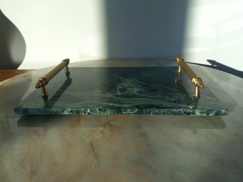 May include: A green marble serving tray with gold metal handles. The tray has a swirling pattern of green and white.