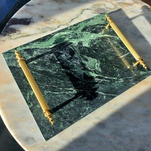 May include: A green marble serving tray with gold handles. The tray has a natural veined pattern.