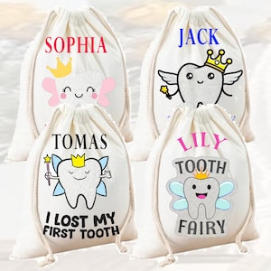 Op de afbeelding: Vier witte trekkoordtassen met tandenfee-ontwerpen. Elke tas heeft een andere naam erop gedrukt: Sophia, Jack, Tomas en Lily. De tassen hebben een tandenfee-ontwerp met een tand, vleugels en een kroon. De tassen zijn perfect om verloren tanden in te bewaren.