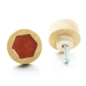 May include: A wooden knob with a red hexagonal inlay. The knob has a screw on the back for attaching to a drawer or cabinet.