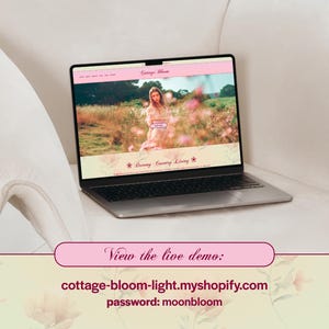 May include: A silver laptop displaying a website with a pink header and a photo of a woman in a field of flowers. The website's name is "Cottage Bloom" and the text "Dreamy Country Living" is visible. The laptop is on a white surface.