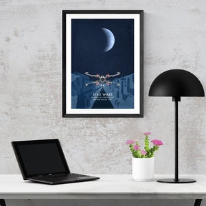 May include: A framed poster featuring a blue and white illustration of a spaceship flying through a city at night. The poster has the text "Star Wars" and "Journey to a Galaxy Far, Far Away" on it.