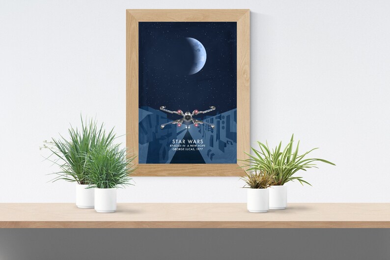 May include: A framed poster with a blue background featuring a crescent moon and a starfighter flying through space. The poster has the text "Star Wars Episode IV: A New Hope George Lucas, 1977".