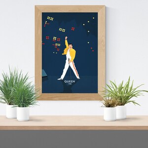 May include: A framed poster with a blue background featuring a cartoon illustration of a person in a yellow jacket and white pants with a microphone. The person is standing with their arm raised in the air. The text "QUEEN 1986" is at the bottom of the poster.