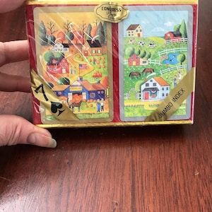 May include: A deck of Congress Playing Cards with a jumbo index. The cards feature a country scene with a red barn, a blue building, and a pumpkin patch. The back of the cards features a green field with a red barn, a white house, and a pond.