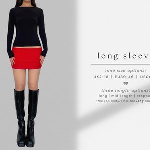 May include: A black long-sleeve shirt with a red mini skirt. The shirt has a boat neck and the skirt is fitted. The model is wearing black knee-high boots. The text on the image reads: "long sleeve", "nine size options: UK2-18 | EU30-46 | US00-14", "three length options: long | mid-length | cropped", "*the top pictured is the long option"