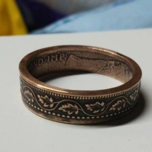 May include: A copper-colored ring made from a coin with a design of leaves and the inscription "IND IMP".