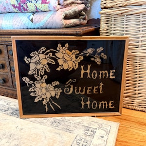 May include: A white ceramic mug with a black handle and the text "But First, Coffee" in a black, bold font. The mug is on a white surface. The mug is approximately 4 inches tall.