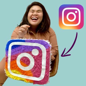 May include: A woman smiles while holding a colorful Instagram logo piñata. The piñata is made of tissue paper and has a rainbow color scheme.