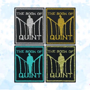 May include: Four embroidered patches with the text "THE BOOK OF QUINT" and a figure on a bridge. The patches are in silver, gold, teal, and gold with black backgrounds.