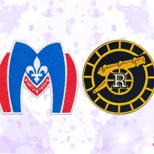 以下が含まれることがあります： 2つの刺繍パッチ。1つは、ユリの紋章とテキストが付いた青と赤の「M」の形です。もう1つは、大砲と文字「R」が付いた黒と金の円形パッチです。