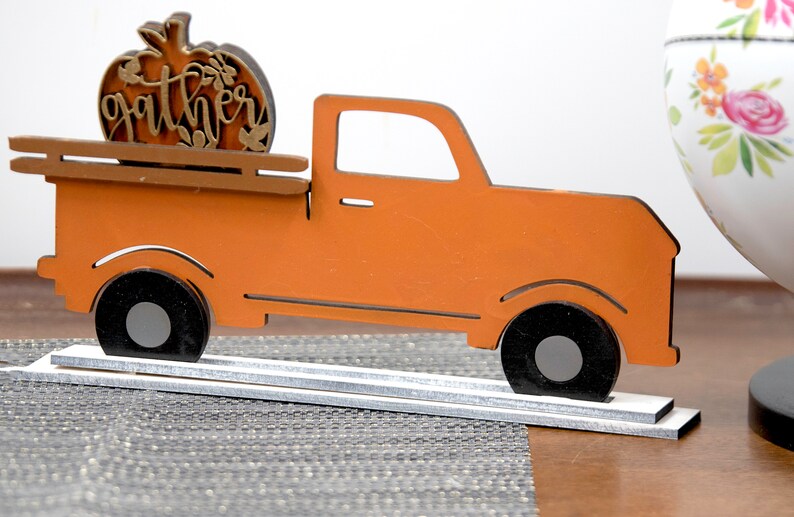Puede incluir: Cami&oacute;n de madera naranja con una calabaza en la parte trasera que dice "gather".