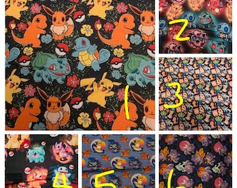 May include: Fabric featuring a repeating pattern of popular cartoon characters, including Pikachu, Charmander, and Eevee, set against a black background with colorful accents. The design includes floral elements and Poké Balls.