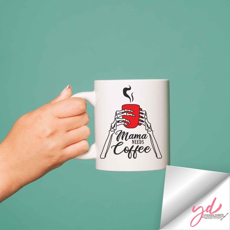 May include: White ceramic coffee mug with a black and white skeleton hand design holding a red coffee cup. The text "Mama Needs Coffee" is printed on the mug.