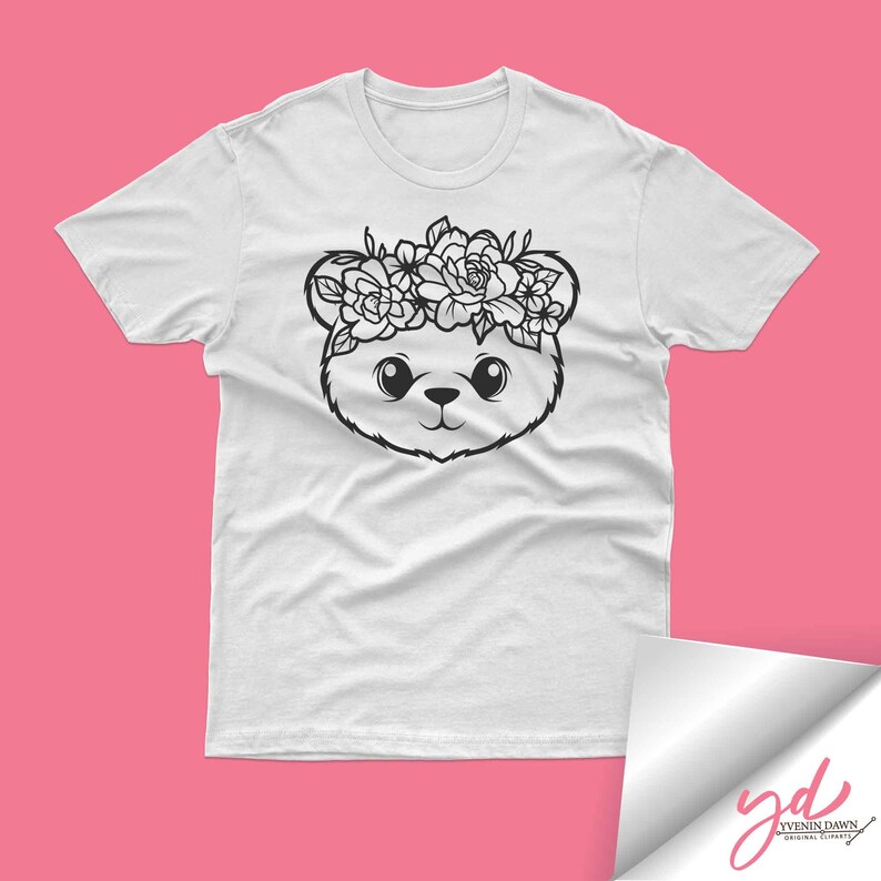 May include: White t-shirt with a black and white illustration of a bear wearing a flower crown.