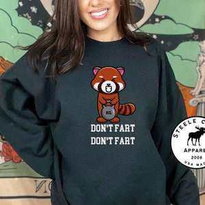 May include: Black sweatshirt with a red panda cartoon lifting a weight and the text "Don't fart Don't fart". The bottom right corner of the sweatshirt has a white circle with black text that reads "Steele Creek Apparel 2008 USA Made".