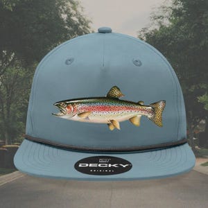 May include: A blue baseball cap with a black brim and a rainbow trout graphic. The cap has the text "DECKY ORIGINAL" on the front.