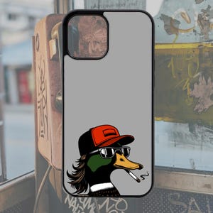 Pu&ograve; includere: Una custodia per telefono con sfondo grigio e un'immagine di un cartone animato di un'anatra che indossa un berretto da baseball rosso, occhiali da sole e fuma una sigaretta.