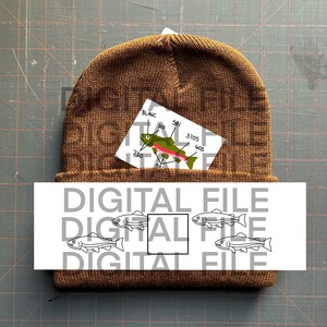 May include: A brown knit beanie with a white tag featuring a cartoon trout illustration and numerical labels. Below the beanie is a white rectangle with the words "DIGITAL FILE" repeated and fish illustrations.
