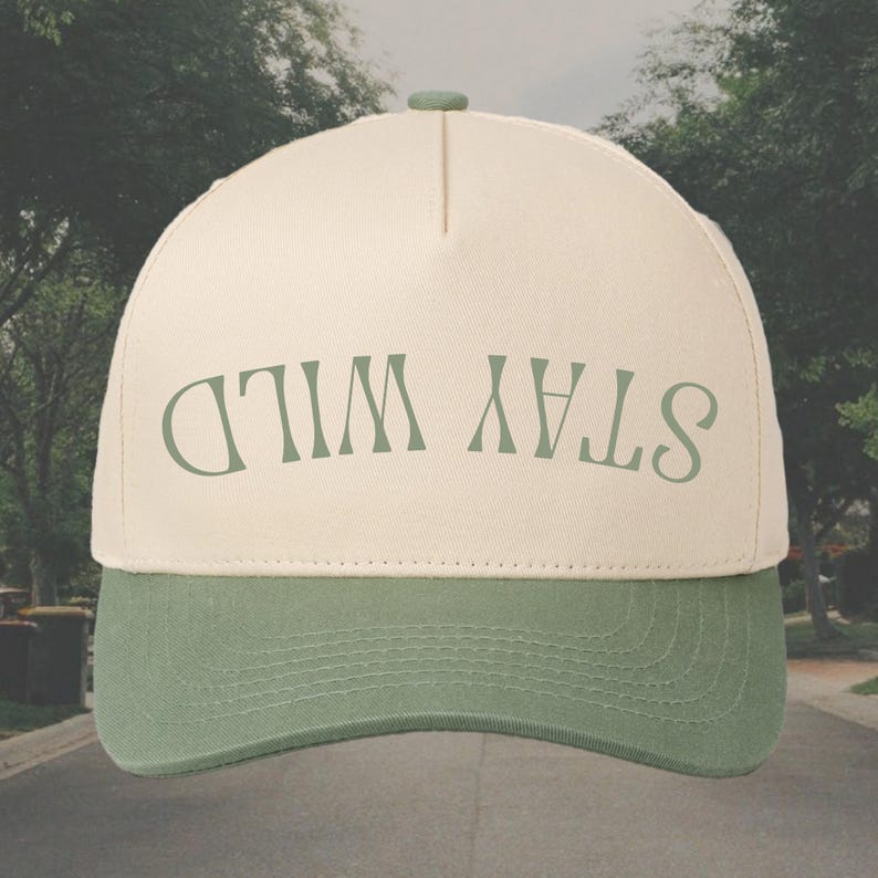 May include: A beige and green baseball cap with the text "STAY WILD" in green lettering.