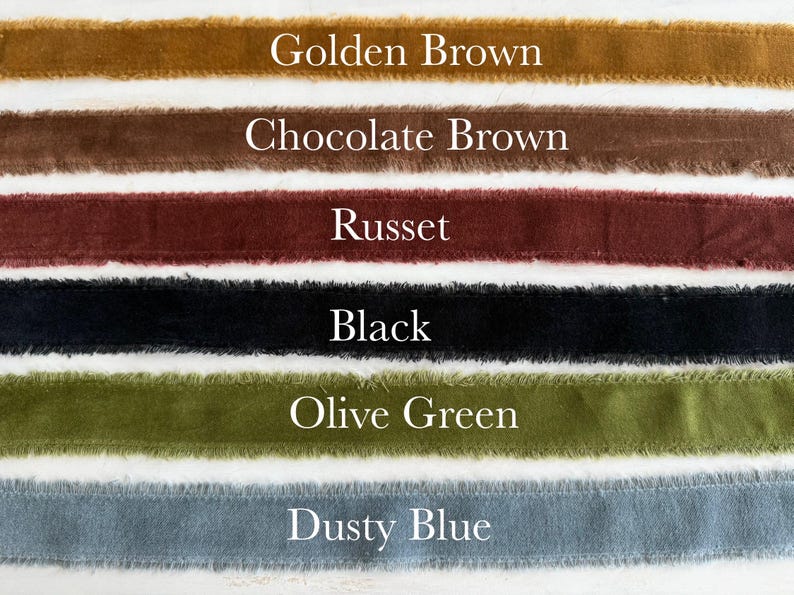 May include: A selection of velvet ribbons in various colors, including golden brown, chocolate brown, russet, black, olive green, and dusty blue. Each ribbon has a frayed edge and is labeled with its color name in white text.