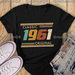 May include: Black t-shirt with a vintage-style graphic that says "Classic 1961 Original" in colorful, striped text.