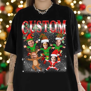 May include: Black t-shirt with a festive Christmas design. The graphic features the word "CUSTOM" in red, with cartoon figures dressed as elves, a reindeer, and Santa Claus. The design is set against a snowy background.