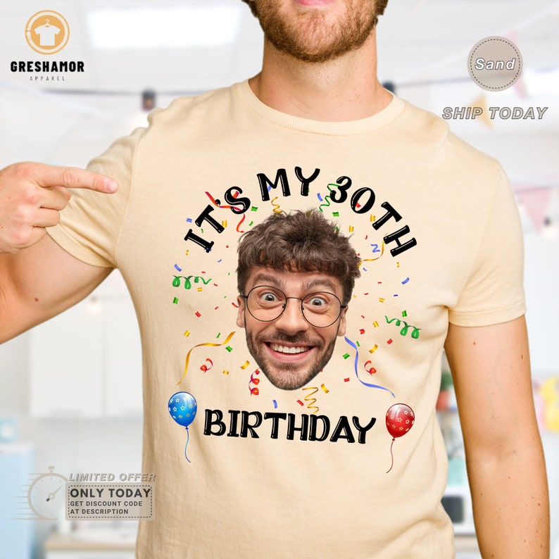 May include: A light yellow t-shirt with the text "It's My 30th Birthday" in black. A man's face is in the center of the shirt, with confetti and balloons surrounding the text.