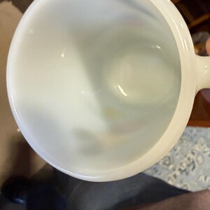 Pu&ograve; includere: Una tazza di ceramica bianca con un corpo arrotondato e un manico. L'interno della tazza &egrave; visibile, mostrando una superficie liscia e lucida. La tazza &egrave; probabilmente progettata per bevande.