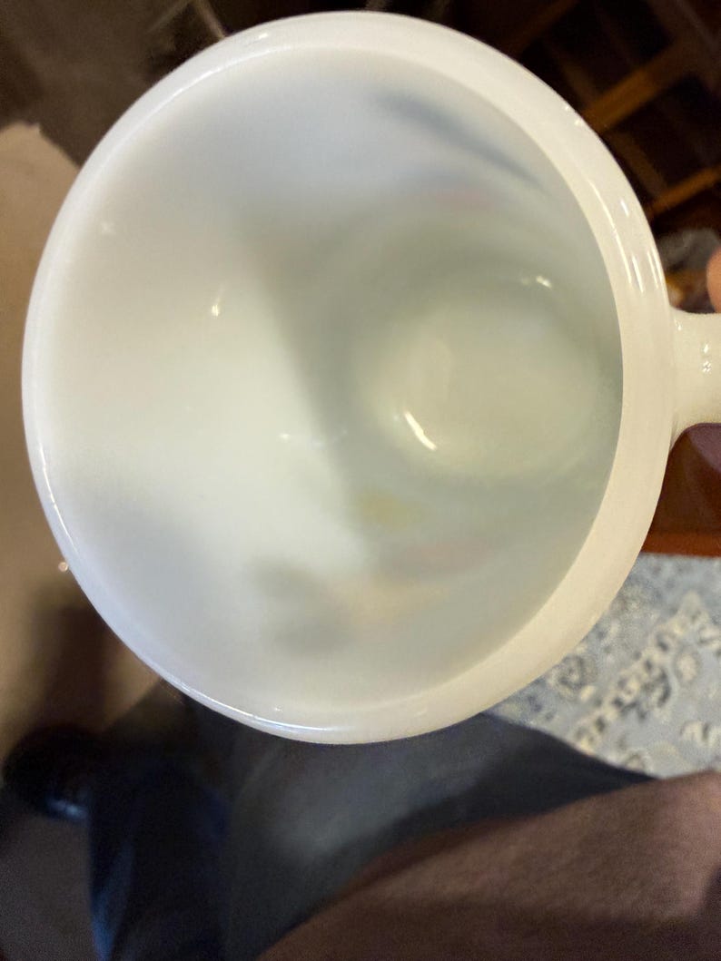 Pu&ograve; includere: Una tazza di ceramica bianca con un corpo arrotondato e un manico. L'interno della tazza &egrave; visibile, mostrando una superficie liscia e lucida. La tazza &egrave; probabilmente progettata per bevande.