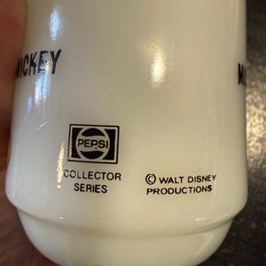 Pu&ograve; includere: Tazza in ceramica bianca della serie Collector Pepsi con il logo Walt Disney Productions. La tazza ha la scritta "Mickey" stampata sopra. Il logo Pepsi &egrave; in un quadrato nero.