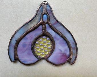 May include: A stained glass suncatcher in the shape of a flower with purple and blue glass and a yellow center.