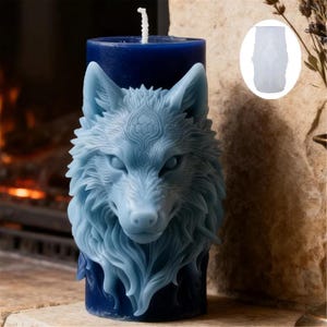 May include: A blue candle featuring a detailed wolf head design. The wolf's head is light blue and sculpted with intricate fur and facial features. The candle has a dark blue base and a white wick.