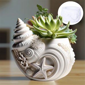 Op de afbeelding: Witte schelpvormige plantenbak met een zeester- en koraalontwerp, gevuld met groene vetplanten en andere planten. De plantenbak heeft een spiraalvormig schelpmotief aan de zijkant en een ronde opening.