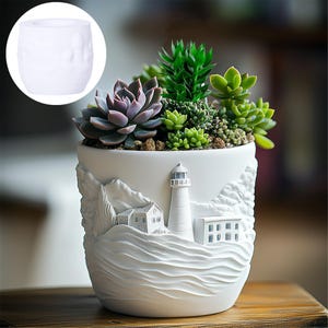 May include: White ceramic planter with a lighthouse, house, and waves design. The planter is filled with succulents.