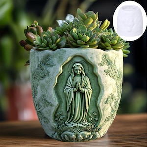 May include: A green ceramic planter with a raised design of a woman in a prayer pose. The planter is filled with green succulents.