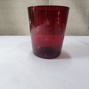 Könnte beinhalten: Ein roter Glasbecher mit einem Sternmuster, das in das Glas geätzt ist.