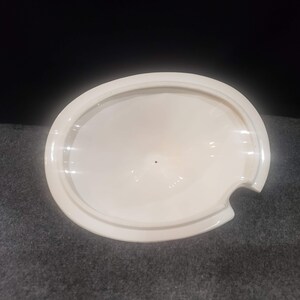 May include: White ceramic lid with a small pour spout. The lid is oval shaped and has a smooth, glossy finish.