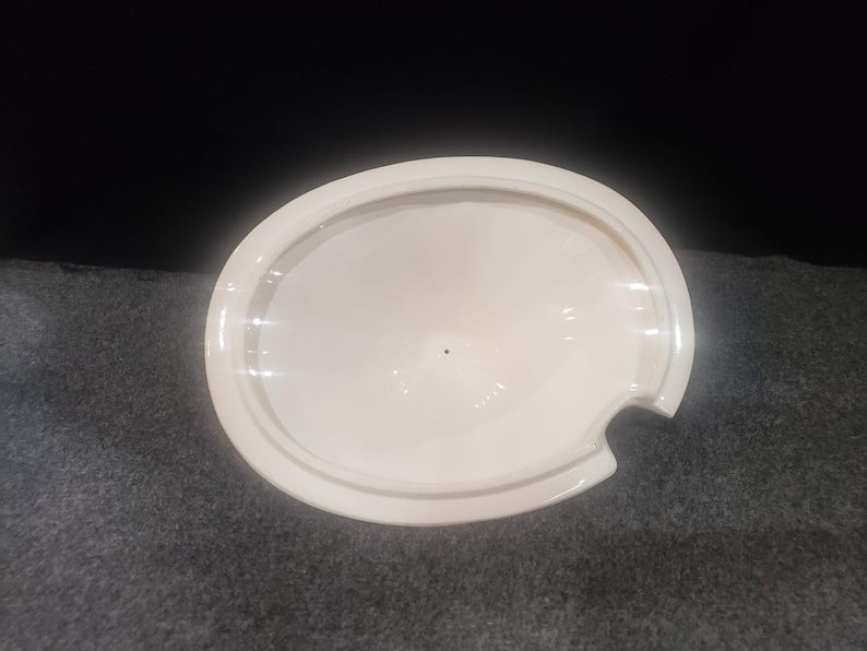 May include: White ceramic lid with a small pour spout. The lid is oval shaped and has a smooth, glossy finish.