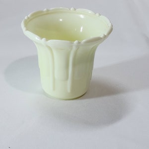 Op de afbeelding: Een kleine, witte keramische pot met een geribbeld ontwerp. De pot heeft een gegolfde rand en is perfect voor kleine planten of vetplanten.