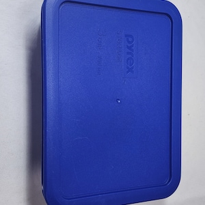 Puede incluir: Tapa de recipiente de almacenamiento de plástico azul con el logotipo de Pyrex y "STORAGE 3 Cup - 750 ml" impreso en ella.
