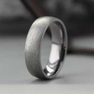 Fede nuziale in tantalio. Finitura opaca effetto ghiaccio. Anello in tantalio puro. Forma a corte. Vestibilità comoda. INCISIONE GRATUITA.