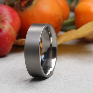 Anillo de bodas de titanio con acabado mate. Forma plana en el exterior. Ajuste cómodo en el interior. Anillo de bodas de titanio. Grabado gratuito.